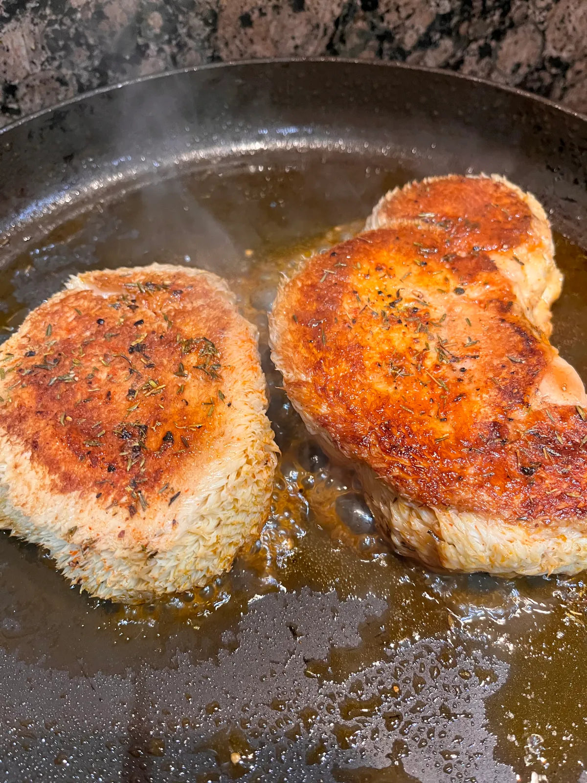 Lion's mane steaks searing in a pan